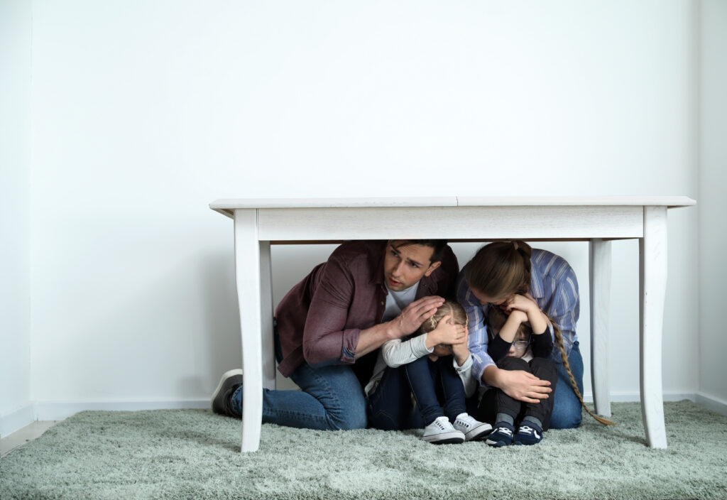 Family under table during earthquake indoors